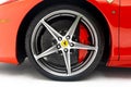 Closeup of a vibrant red Ferrari wheel isolated on white background Royalty Free Stock Photo