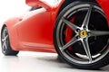 Closeup of a vibrant red Ferrari wheel isolated on white background Royalty Free Stock Photo