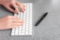 Closeup video of female hands, typing on the PS keyboard, at the table in the office