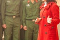 Closeup of Vietnamese professor woman in red long coat lecturing to young vietnamese soldier