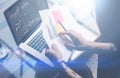 Closeup view of adult tattooed coworker working with laptop at workplace.Businessman analyze documents on hands.Graphs