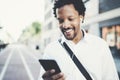 Closeup view of Attractive american african black man listening to music with headphones in urban background. Happy men Royalty Free Stock Photo