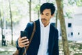 Closeup view of attractive young businessman using smartphone for listining music while walking in city park.Horizontal Royalty Free Stock Photo