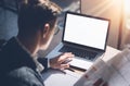 Closeup view of banking finance analyst in eyeglasses working at sunny office on laptop while sitting at wooden table Royalty Free Stock Photo