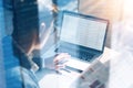 Closeup view of banking finance analyst in eyeglasses working at sunny office on laptop while sitting at wooden table Royalty Free Stock Photo