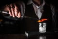 Closeup view of bartender hands preparing cocktail. Experimenting with new recipe to make a cocktail