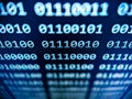 Closeup view of binary computer code with 1s and 0s displayed on a blue screen with focus blur effect