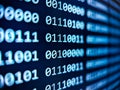 Closeup view of binary computer code with 1s and 0s displayed on a blue screen with focus blur effect