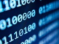 Closeup view of binary computer code with 1s and 0s displayed on a blue screen with focus blur effect