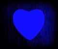 Closeup view of a blue-colored heart-shaped object on a blue wooden surface - concept: love Royalty Free Stock Photo