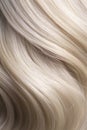 A closeup view of a bunch of shiny straight blond hair in a wavy style.