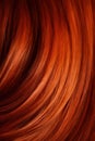 A closeup view of a bunch of shiny straight red hair in a wavy curved style.