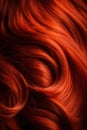 A closeup view of a bunch of shiny straight red hair in a wavy curved style.