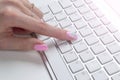 Closeup view of a business woman hand typing on wireless computer keyboard on office table. Soft lightning. Royalty Free Stock Photo