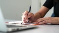 Closeup view of businesswoman writing on paper with pen.