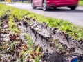 Closeup view of car wheel tracks traces in mud next to British road Royalty Free Stock Photo