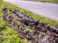 Closeup view of car wheel tracks traces in mud next to British road Royalty Free Stock Photo