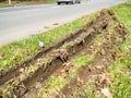 Closeup view of car wheel tracks traces in mud next to British road Royalty Free Stock Photo