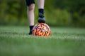 Closeup view of a childs foot in a soccer shoeas on top of soccer ball