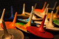 Closeup view of colorful handmade painted wooden toys - peg tops or whirligigs as creative background with blurred light gold Royalty Free Stock Photo