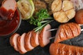Closeup view of delicious grilled sausages and on dark table, flat lay Royalty Free Stock Photo