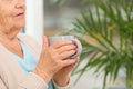 Closeup view of elderly woman with cup of tea in nursing home, space for text. Assisting Royalty Free Stock Photo