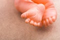 Closeup view of the feet of plastic baby toys on a beige surface Royalty Free Stock Photo