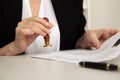 Closeup view of female hand holding stamp and notarized paper. Royalty Free Stock Photo