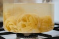 Closeup view of fettuccine pasta into boiling water in a saucepan