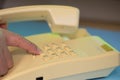 Closeup view of finger dialing telephone number on old style wired desktop telephone - studio shot Royalty Free Stock Photo