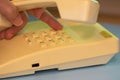 Closeup view of finger dialing telephone number on old style wired desktop telephone - studio shot Royalty Free Stock Photo
