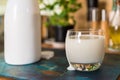 Closeup view fresh kefir probiotik drink in clear glass and white bottle on kitchen table