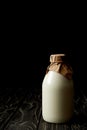 closeup view of fresh milk in bottle wrapped by paper on black background Royalty Free Stock Photo