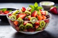 Fruit salad with strawberry, kiwi, watermelon and mint in glass bowl. Generative AI. Royalty Free Stock Photo