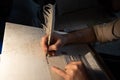 Closeup view of the hands of a Jewish scribe writing the words of the Shema Yisrael prayer on parchment that will be encased in a