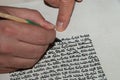 Closeup view of the hands of a Jewish scribe writing the Hebrew text of the Torah or Bible on parchment using a feather quill and