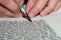 Closeup view of the hands of a Jewish scribe writing the Hebrew text of the Torah or Bible on parchment using a feather quill and