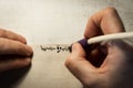 Closeup view of the hands of a Jewish scribe writing the words of the Shema Yisrael prayer on parchment that will be encased in a