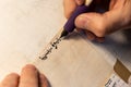 Closeup view of the hands of a Jewish scribe writing the words of the Shema Yisrael prayer on parchment that will be encased in a Royalty Free Stock Photo