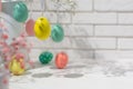 Closeup view of hanging fake eggs on table with brick wall with copy space. Decorated interior