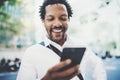 Closeup view of Happy american African man using smartphone outdoor to texting a sms message with friends.Portrait of Royalty Free Stock Photo