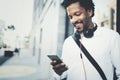 Closeup view of Happy smiling African man using smartphone outdoor.Portrait of young black cheerful man texting a sms Royalty Free Stock Photo