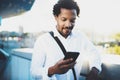 Closeup view of Happy smiling African man using smartphone outdoor.Portrait of young black cheerful man texting a sms Royalty Free Stock Photo