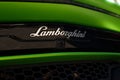 Closeup view of the hood and exhaust pipe of a green Lamborghini car featuring an emblem. Royalty Free Stock Photo