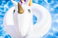 Closeup view of Inflatable colorful white unicorn at the swimming pool. Fun time in the Summer at swimming pool. concept.