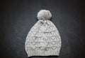 Closeup view of knighted girl's stylish light grey winter hat on dark background Royalty Free Stock Photo