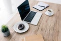 closeup view of laptop with blank screen, doughnut, coffee cup, potted plant