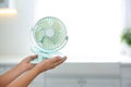 Closeup view of little child with portable fan on blurred background, space for text. Summer heat Royalty Free Stock Photo