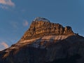 Majestic Pilot Mountain with rugged rock face and snow in the orange morning light in autumn in the Rocky Mountains, Canada. Royalty Free Stock Photo