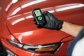 Closeup view of male hand, using film coating thickness gauge device to check car paint. Royalty Free Stock Photo